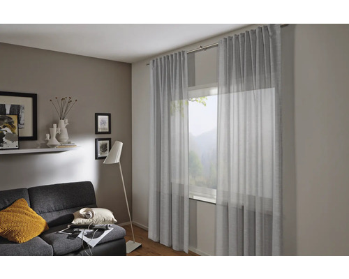 Obývací pokoj se záclonami, pohovkou a stojací lampou pro útulnou atmosféru