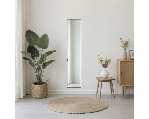 Pohled do místnosti s obdélníkovým zrcadlem, rostlinou a komodou