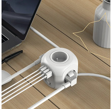Kostka zásuvky s USB porty na stole s notebookem a vázou