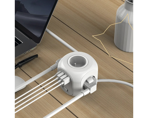 Kostka zásuvky s USB porty na stole s notebookem a vázou