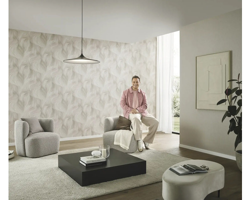 Moderní obývací pokoj se vzorovanou tapetou, dvě křesla, konferenční stolek a osoba