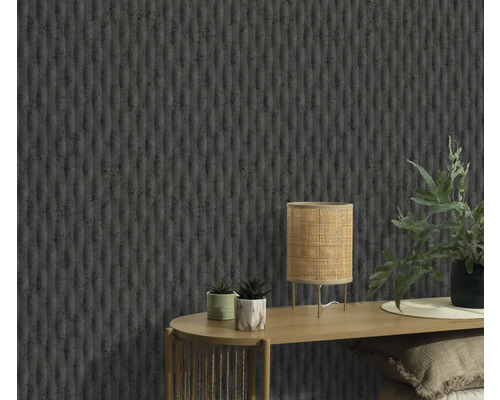 Detail stěny se strukturovanou tapetou, stolu s lampou a rostlinami