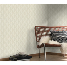 Obývací pokoj s geometrickou tapetou, židlí a dekorativními prvky pro stylové prostředí.