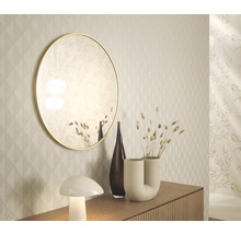 Dekorativní interiér se zrcadlem, vázami a lampou na příborníku před vzorovanou tapetou.