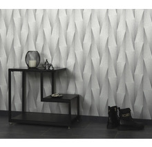 Pohled do místnosti s tapetou se vzorem, dekoracemi na příručním stolku a botami