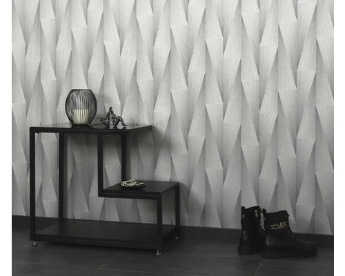 Pohled do místnosti s tapetou se vzorem, dekoracemi na příručním stolku a botami