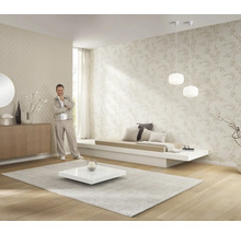 Světlý obývací pokoj s tapetami se vzory, nízkou pohovkou, kobercem a dekorací