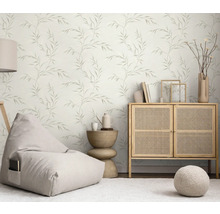 Světlý obývací pokoj s tapetou s motivem listů, sedacím vakem, komodou a odkládacím stolkem