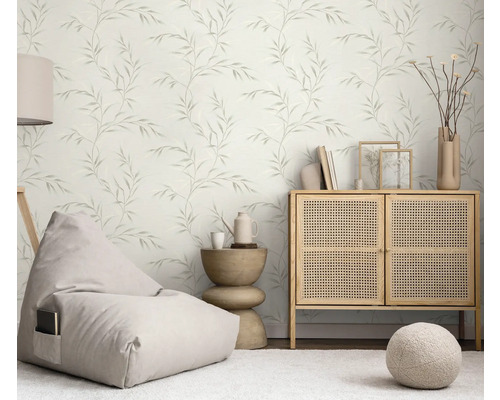 Světlý obývací pokoj s tapetou s motivem listů, sedacím vakem, komodou a odkládacím stolkem