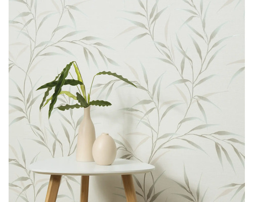 Dekorativní tapeta s motivem listů, kombinovaná se stolem a pokojovými rostlinami ve vázách.
