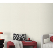 Obývací pokoj s lavicí, polštářem a dekorací před světlou stěnou