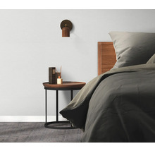 Ložnice s postelí, nočním stolkem, lampou a rozprašovačem vůní