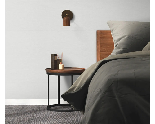 Ložnice s postelí, nočním stolkem, lampou a rozprašovačem vůní