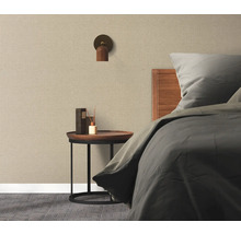 Ložnice s postelí, nočním stolkem, nástěnnou lampou a textilní tapetou