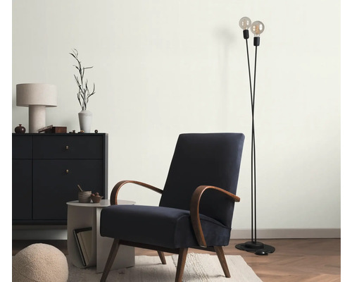 Obývací pokoj s křeslem, stojací lampou a komodou pro útulnou atmosféru.