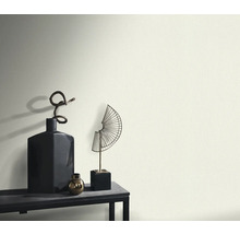 Dekorativní vázy a sochy na stole před zdí