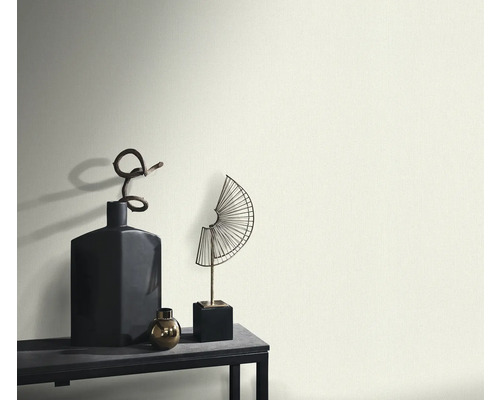 Dekorativní vázy a sochy na stole před zdí