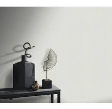 Detail strukturované stěny s dekorativními předměty na polici.