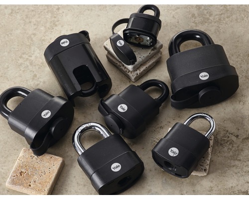 Různé černé visací zámky Yale na rovném povrchu.