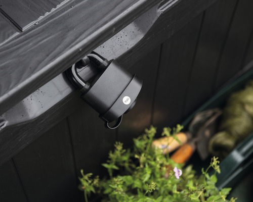 Černý visací zámek Yale připevněný k černé dřevěné bedně