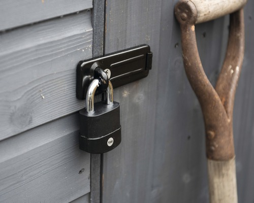 Visací zámek na dveřích zahradního domku s rýčem