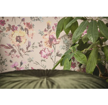 Dekorativní tapeta s květinovým vzorem a pokojová rostlina v popředí.