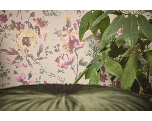 Dekorativní tapeta s květinovým vzorem a pokojová rostlina v popředí.