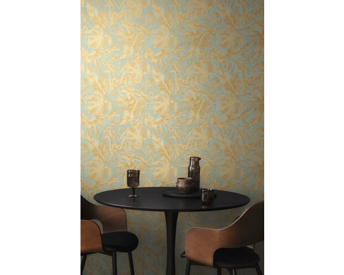 Scéna se stolem, židlemi a stěnou s tapetou s listovým vzorem.