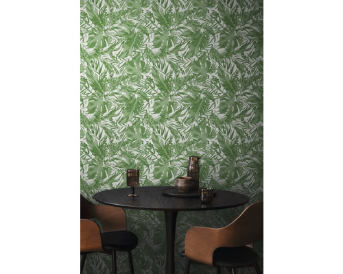 Jídelna se zelenou tapetou s listy, kulatým stolem a židlemi