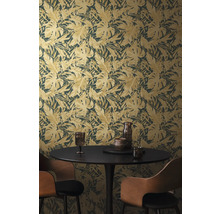 Pokoj s tapetou s motivem listů, jídelním stolem a židlemi.