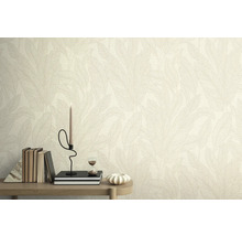 Stěna s tapetou se vzorem listů, zdobená knihami, svíčkou a přesýpacími hodinami na stole.