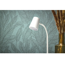 Detail strukturované tapety s listovým vzorem, bílé lampy a vázy s okrasnou trávou