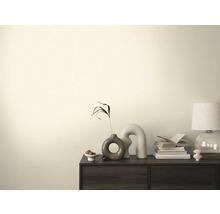 Obývací pokoj s komodou, stolní lampou, knihami a dekoracemi.