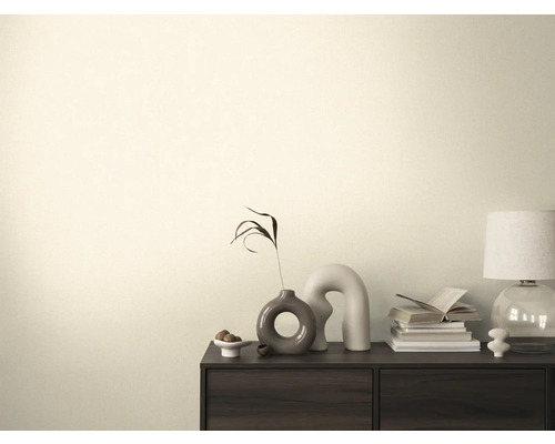 Obývací pokoj s komodou, stolní lampou, knihami a dekoracemi.