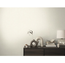 Dekorativní místnost s komodou, na které jsou knihy, lampa a vázy.