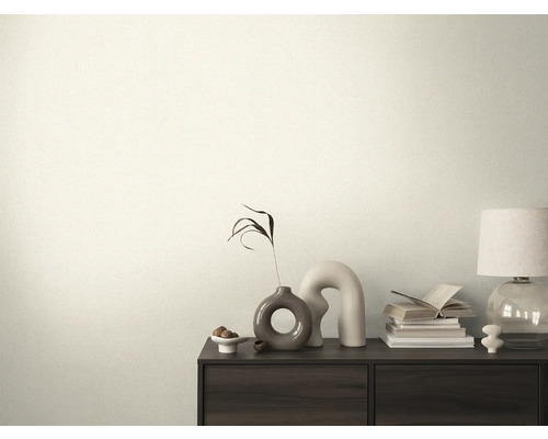 Dekorativní místnost s komodou, na které jsou knihy, lampa a vázy.