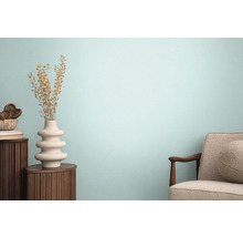 Obývací pokoj s křeslem, dřevěným stolem a ozdobnou vázou