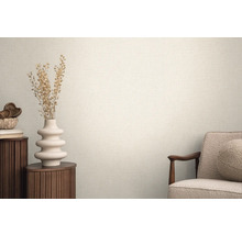 Světlá místnost se strukturovanými tapetami, zdobená vázou a křeslem pro útulnou atmosféru.