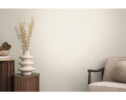 Světlá místnost se strukturovanými tapetami, zdobená vázou a křeslem pro útulnou atmosféru.