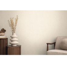 Obývací pokoj s textilní tapetou, křeslem, kulatým odkládacím stolkem a dekorací