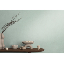 Dekorativní uspořádání na dřevěném stole před stěnou s textilní tapetou