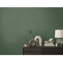 Detailní záběr zelené textilní tapety na stěně za skříňkou.