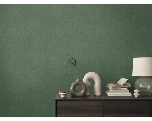 Detailní záběr zelené textilní tapety na stěně za skříňkou.