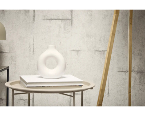 Dekorativní stěna s cementovou strukturou a opřeným dřevěným prvkem.