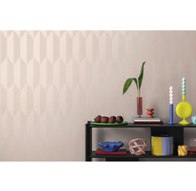 Dekorativní předměty na polici před stěnou s geometrickým vzorem