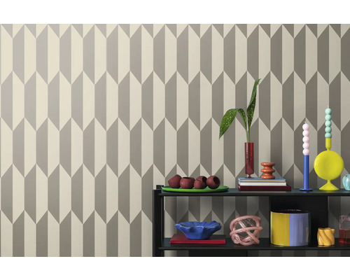 Tapeta s geometrickým šípovým vzorem za policí s dekoracemi.