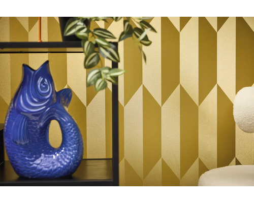 Pohled do místnosti s geometrickou tapetou a dekorativní váza ve tvaru ryby