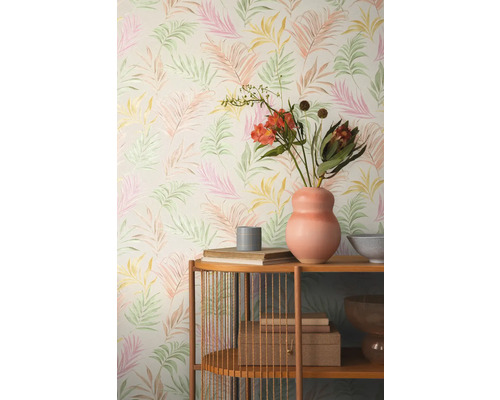 Pohled do pokoje s tapetou se vzorem listů a dřevěným regálem s dekorativními předměty