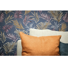 Dekorativní tapeta s designem listů a polštáře v popředí.