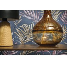 Dekorativní scéna s lampou, vázou a vzorovanou tapetou.